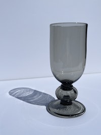 a black glass goblet on a white surface